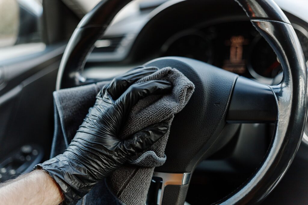 man-s-hand-in-black-glove-cleaning-car-interior-d7-min