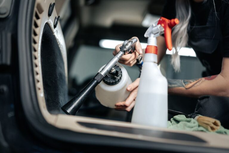 woman-cleaning-car-salon-with-polishing-spray-in-c-min